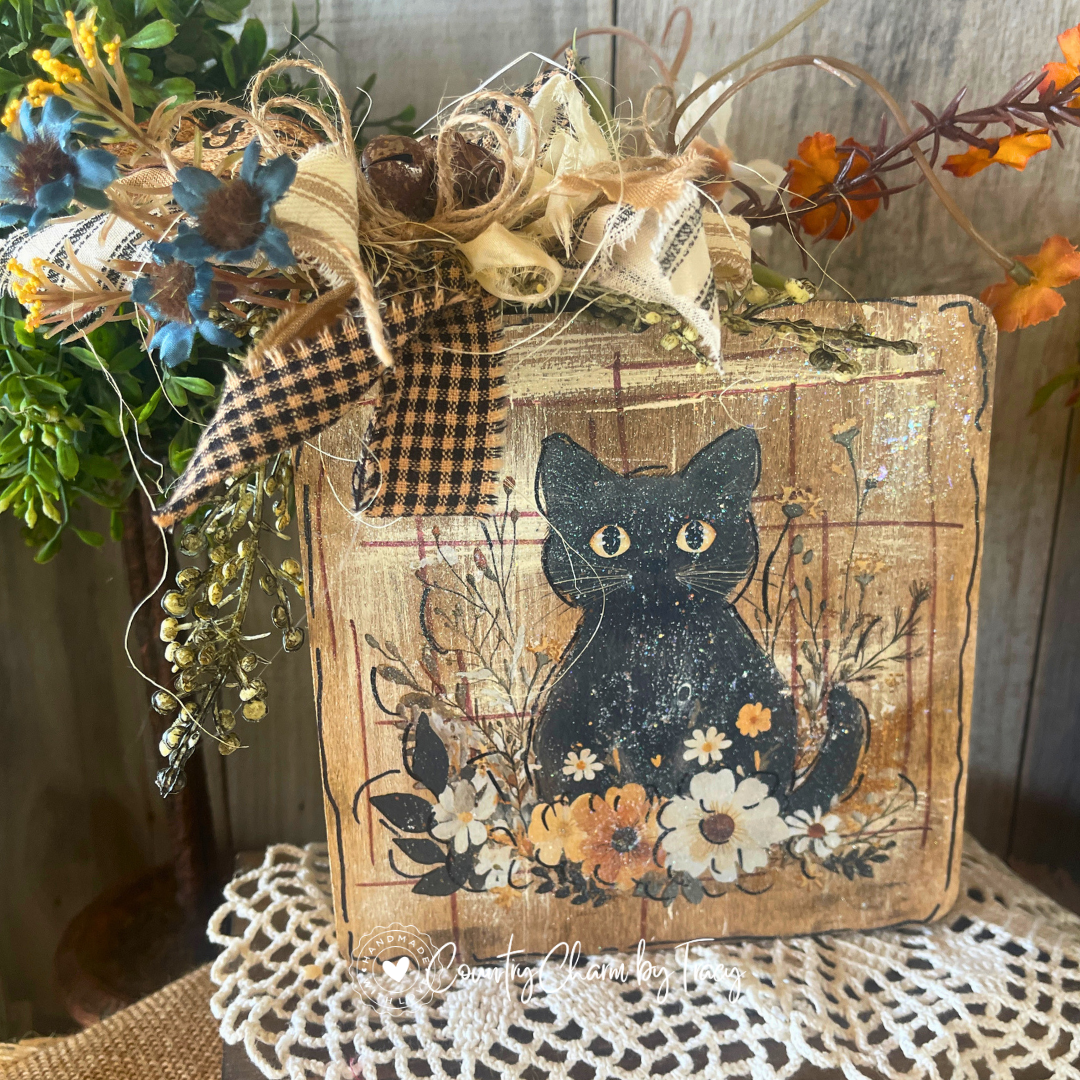 Hey Boo black cat 6x6 wood block decor with whimsical black cat wildflower artwork distressed aged wood background black plaid cream newsprint bow rusty jingle bells blue orange florals twig branches and Hey Boo tag by Country Charm by Tracy