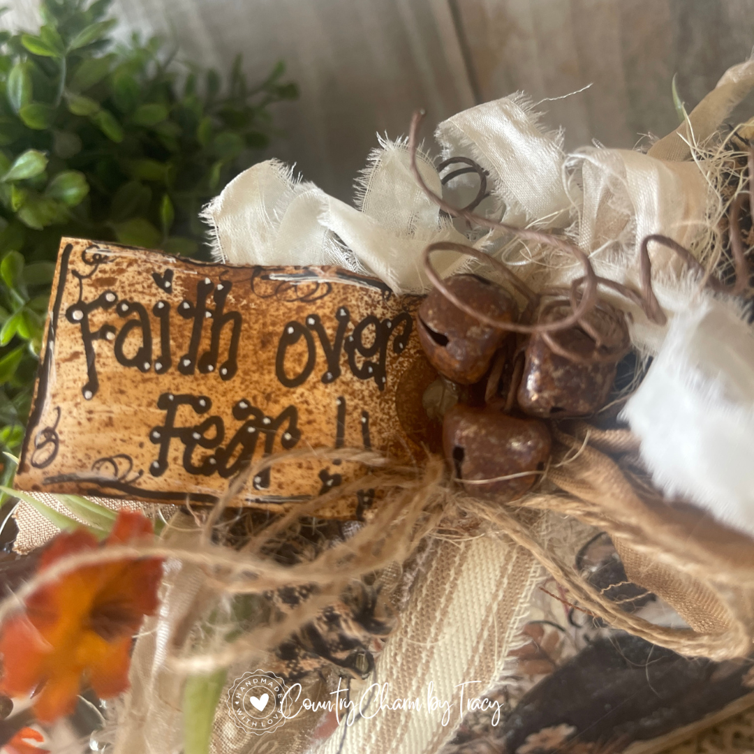 Close up of Faith Over Fear Fluffy Tuxedo Kitty Wood Block Decor showing hand-lettered faith over fear distressed tag rusty jingle bell cluster curly wire and layered gold scroll cream ribbon bow with wispy raffia by Country Charm by Tracy