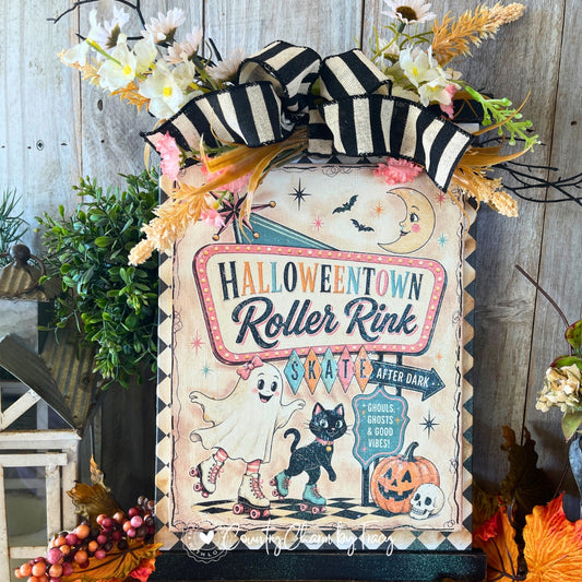 Halloweentown Roller Rink retro Halloween sign decor with vintage marquee typography rollerskating ghost black cat jack-o-lantern crescent moon bats white daisy pink carnation floral swag black white striped bow and jute hanger by Country Charm by Tracy